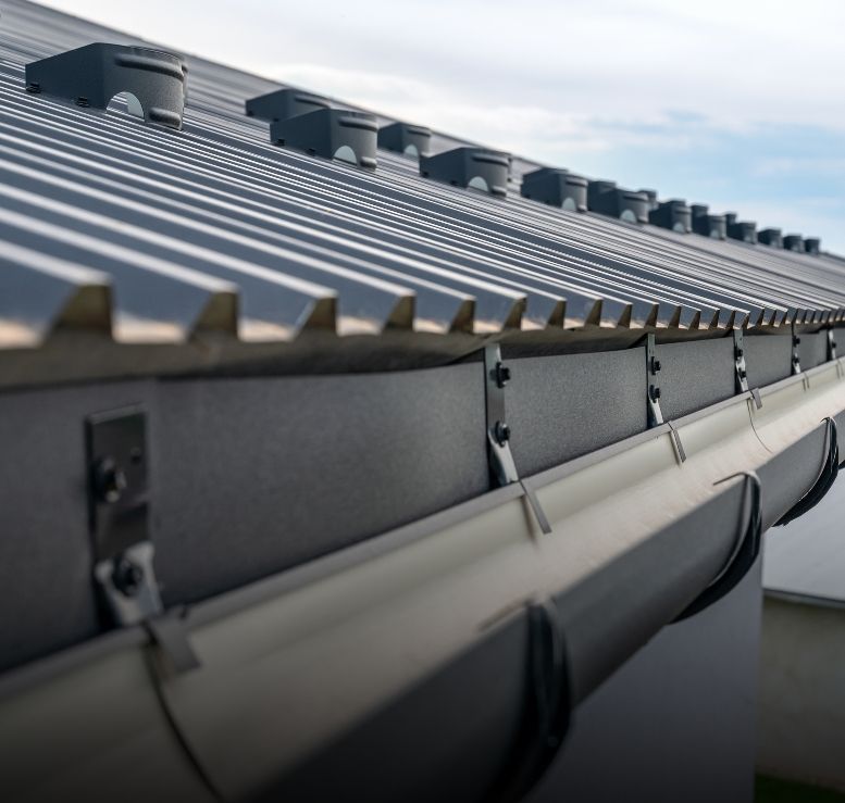 Gouttière et descente le long d’une toiture équipée de panneaux solaires