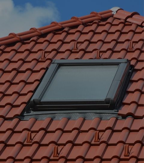 Fenêtre de toit Velux neuve posée sur une toiture en tuiles