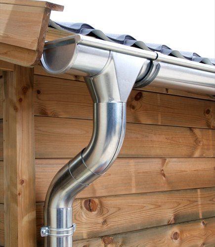 Gouttière et descente en zinc sur un bâtiment en bois